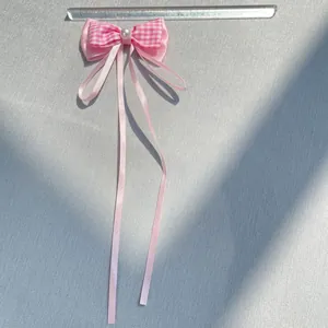 Pink plaid bow accessory with white pearl and long ribbons, measures 10cm wide