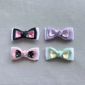 Detailed view of four colorful polka dot layered bow hair clips with heart charms