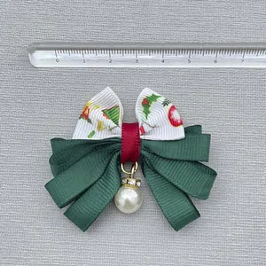 Detail shot of Christmas bow hair clip with faux pearl pendant measuring 6.5cm wide