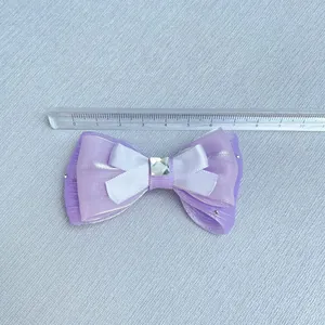 Close-up of 8cm purple organza bow with rhinestone center and size reference ruler