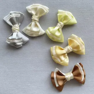Detail van vijf meerlaagse gaas en satijnen strikaccessoires in diverse neutrale kleuren