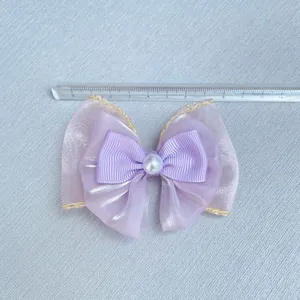Detail shot of purple organza bow with faux pearl measuring approximately 8.5cm wide