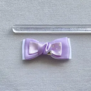 Purple satin polka dot bow hair clip with crystal heart accent and 6.5cm size reference
