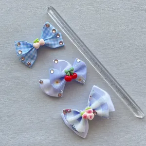 Detailweergave van handgemaakte haarstrikken met kersen- en aardbeibedeltjes op een liniaal