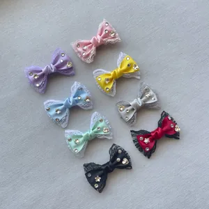 Dettaglio di fiocchi in raso da 6 cm fatti a mano con pizzo e strass a forma di stella