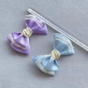 Detail van gelaagde satijnen strikken in paars en blauw met liniaal voor de afmeting