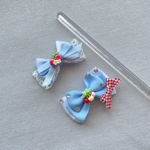 Gedetailleerd bovenaanzicht van handgemaakte blauwe haarstrikjes met kant en kersenmotief