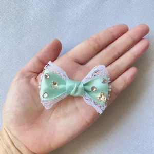 Dettaglio fiocco verde menta 6cm con pizzo bianco e strass in cristallo lucido