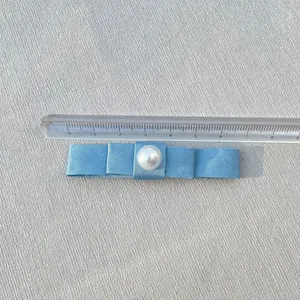 Detail of 80mm light blue satin bow hair clip with a centered white faux pearl bead
