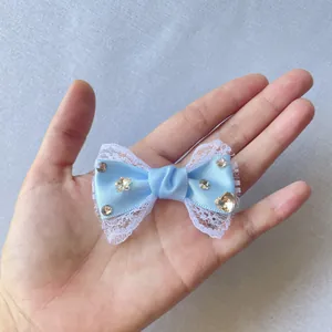 Dettaglio fiocco in raso azzurro da 6cm con pizzo bianco e strass scintillanti