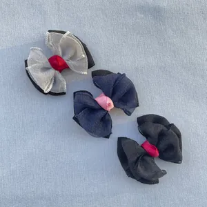 Gros plan de trois nœuds en tulle multicouches gris, bleu et noir avec centre satiné