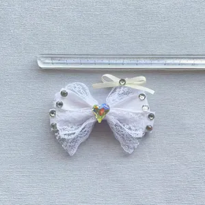Dettaglio dimensioni del fiocco in pizzo bianco con strass e gemma a forma di cuore