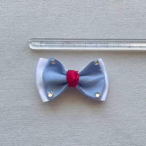 Detailopname van de 6,5 cm blauw-witte strik met rode knoop en sprankelende strass