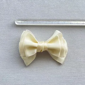 Detailweergave van een crème gaasstrik van 7-8 cm met een transparante liniaal voor maat
