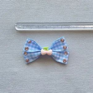 Detail van 4,5cm blauwe ruitjes strik haarclip met kers en kristallen decor