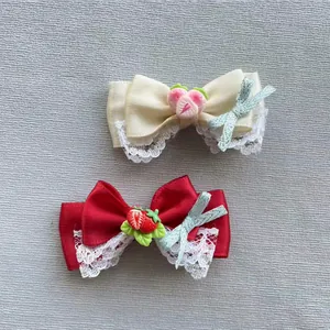 Detail von Satin-Schleifenclips mit Harzfrüchten und zarter Spitze für das Haar