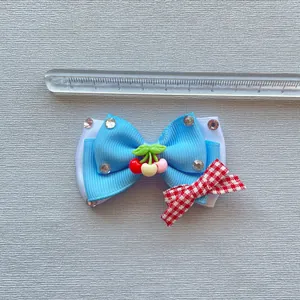 Handgemaakte blauwe en rode haarcadeau-strik met kersenhars en glanzende strassteentjes