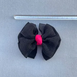 Détail d'un nœud en organza noir de 11,5 cm avec nœud rose et tissu texturé épais