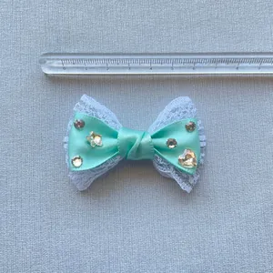 Fiocco in raso verde menta con pizzo bianco e strass, largo 6,5 cm con righello