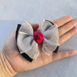 Détail d'un nœud en organza multicouche avec rubans noir, blanc et rouge pour accessoires