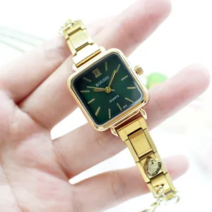 Détail de montre vintage à cadran vert avec bracelet doré orné de papillons ciselés