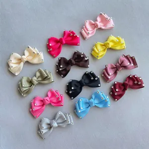 Flat lay of 12 colorful grosgrain ribbon bow clips with rhinestones for hair and crafts