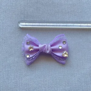 Dettaglio di un fiocco in seta viola da 6 cm fatto a mano con pizzo e strass lucidi