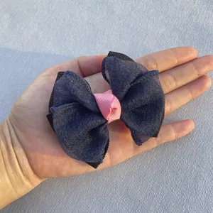 Détail d'un nœud en tulle scintillant bleu marine avec centre en ruban rose et base noire