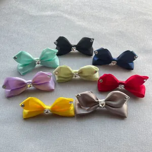 Dettaglio di fiocchi in raso con strass per capelli in otto vivaci colori assortiti