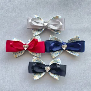 Gros plan de quatre nœuds en tissu floral avec strass en cœur en gris rouge bleu noir