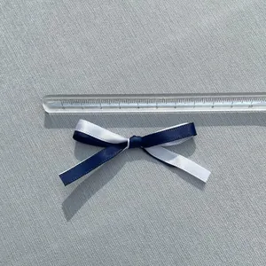 Detailansicht einer 5,5cm zwelagigen Satin-Schleife in Weiß und Marineblau für Haarschmuck