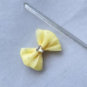 Dettaglio macro del fiocco in tulle giallo con punti d'argento e cristallo