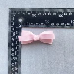 Pink grosgrain ribbon bow accessory with double-layered design measuring 4.5cm in length