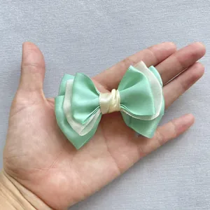 Detail van een meerlaagse mintgroene en beige satijnen strik voor DIY-accessoires