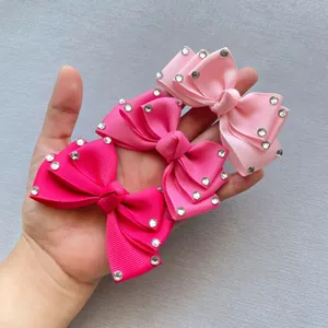 Detailed view of handmade pink grosgrain ribbon bow hair clips with sparkly rhinestones