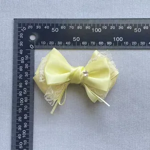 Yellow satin bow with lace trim and star rhinestone, 12cm width measurement view