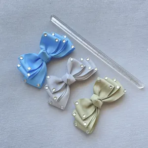 Close-up of three-piece set rhinestone bow hair clips in blue, grey and green