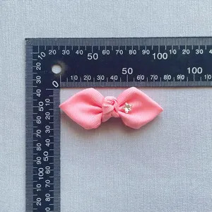 Macro view of pink grosgrain ribbon bow featuring a crystal star detail and measuring tool