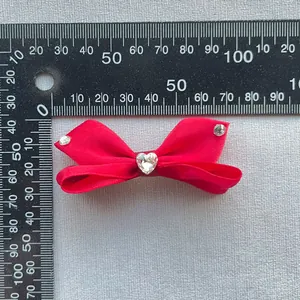 Dettaglio fiocco rosso con strass a cuore e righello per misurazione di 85-90mm