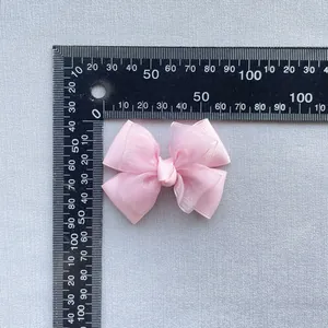 Detail of pink double-layered bow accessory showing ribbed ribbon and organza texture
