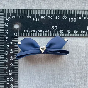 Dettaglio ravvicinato del fiocco in raso blu con strass a forma di cuore al centro