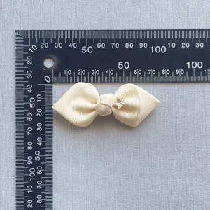 Detail of 50mm cream grosgrain ribbon bow with a tiny crystal star for hair accessories