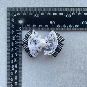 Macro detail of plaid ribbon bow with lace trim and faux pearl for DIY accessories