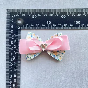 Nœud floral en tissu et satin rose avec cœur en cristal et mesure de la taille
