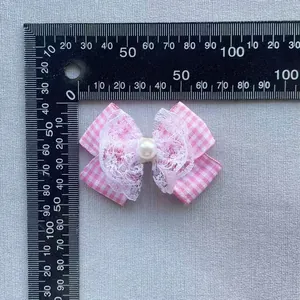 Detailed close-up of a pink plaid bow with white lace and pearl, size measured at 5cm