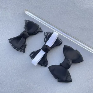 Detail view of handmade black and white fabric bows with a transparent ruler for size