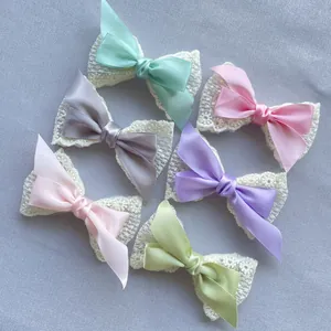 Detail von doppellagigen Spitzen- und Satin-Schleifen in sechs Macaron-Farben für Accessoires