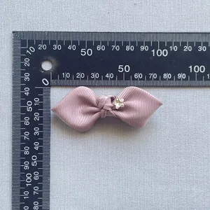 Grosgrain ribbon bow in dusty pink with star rhinestone showing 5.5cm width measurement