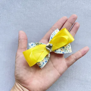 Détail d'un nœud papillon double épaisseur en tissu floral et satin jaune avec cœur