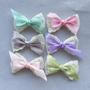 Detailansicht von sechs zweilagigen Schleifen aus Spitze und Satin in Pastellfarben